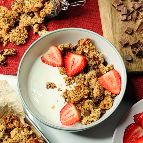 chunky granola in a bowl with yoghurt and strawberries